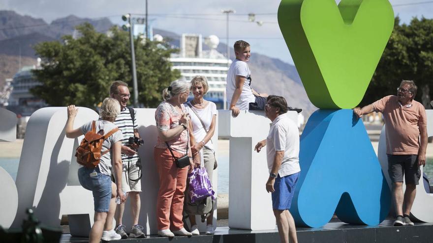 Un grupo de turistas se fotografía en la plaza de España de Santa Cruz de Tenerife.