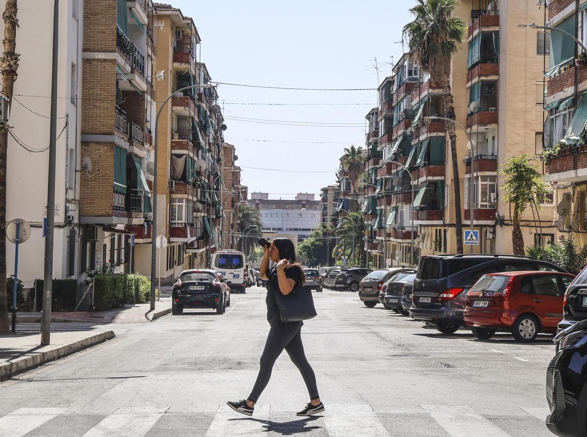 Una joven caminando por un barrio de la ciudad de Alicante con una baja renta media.