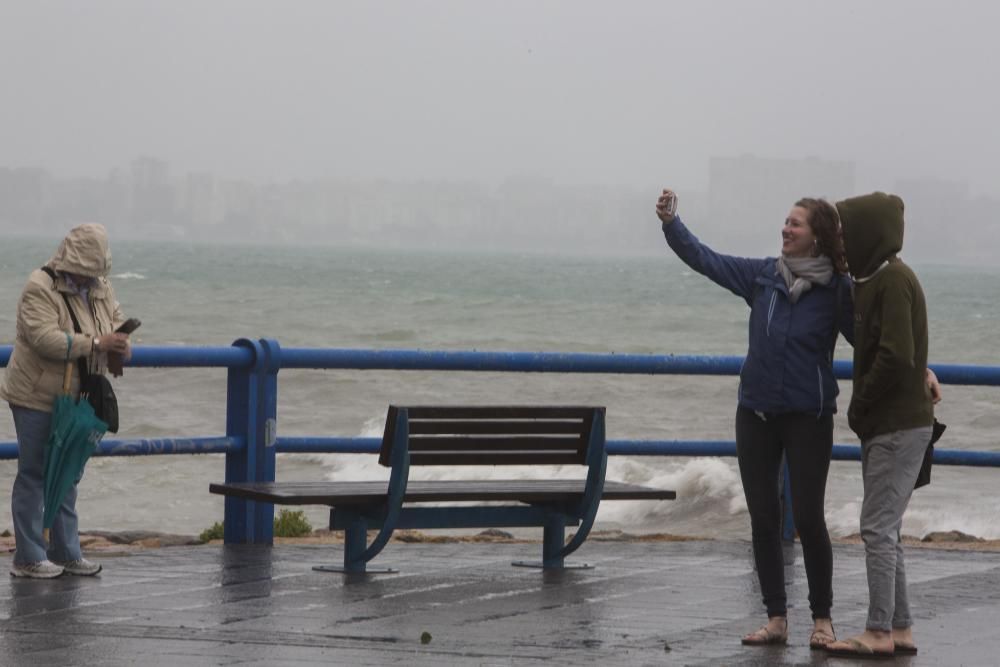 Imágenes del temporal de lluvia y viento en la playa del Postiguet en Alicante.