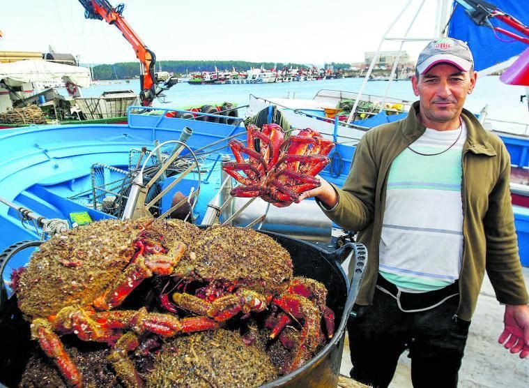Un pescador de O Grove junto a un capazo de centollos.