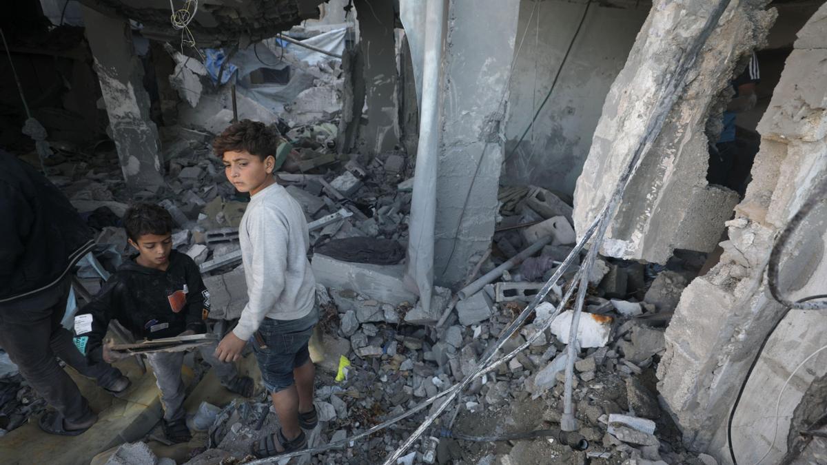 Niños palestinos inspeccionan una casa destruida tras un ataque aéreo israelí en la Franja de Gaza.