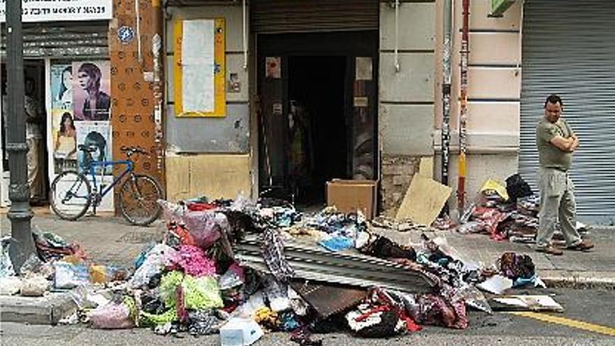 Ropa y otros enseres destrozados en el incendio de esta tienda de Russafa.