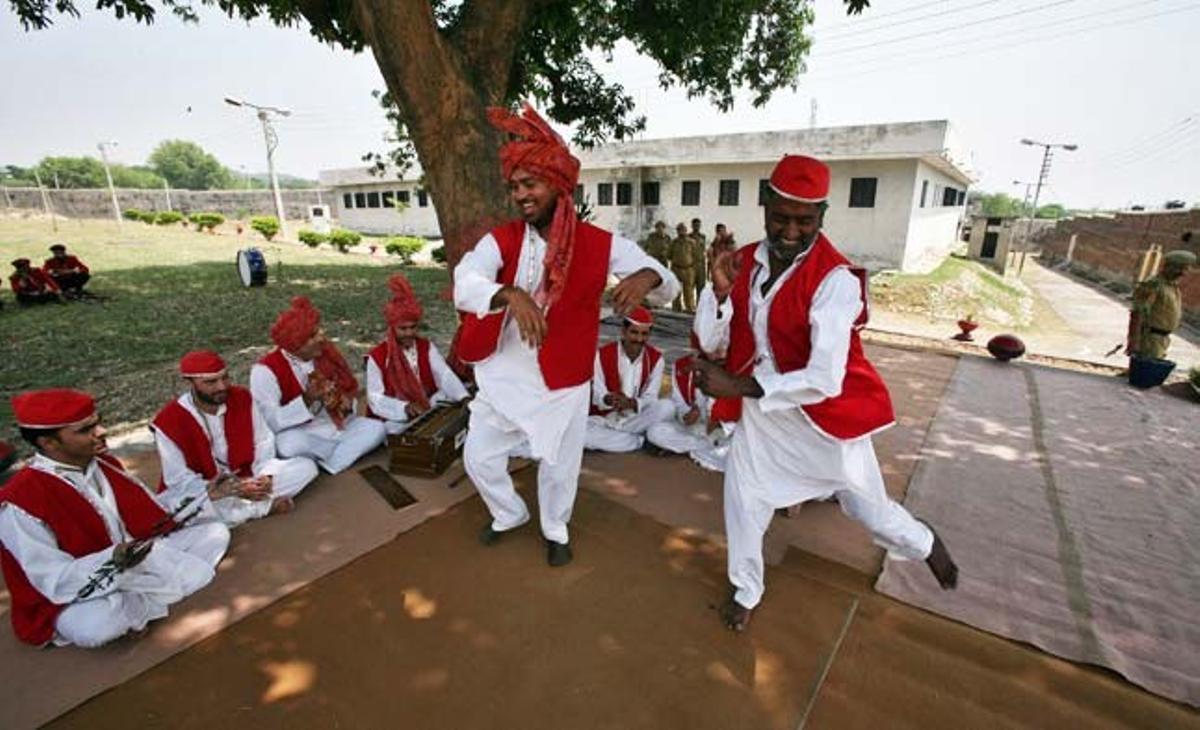 Diversos presoners toquen instruments musicals i ballen com a part del seu programa de reinserció social a la presó central de Kotbhalwal (Índia).