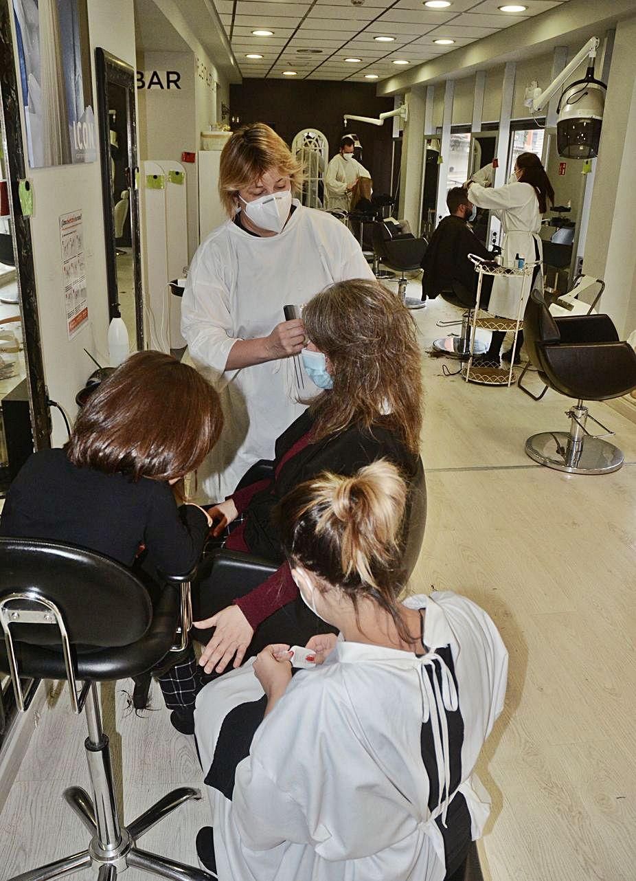 Trabajadoras de una peluquería, con una clienta.