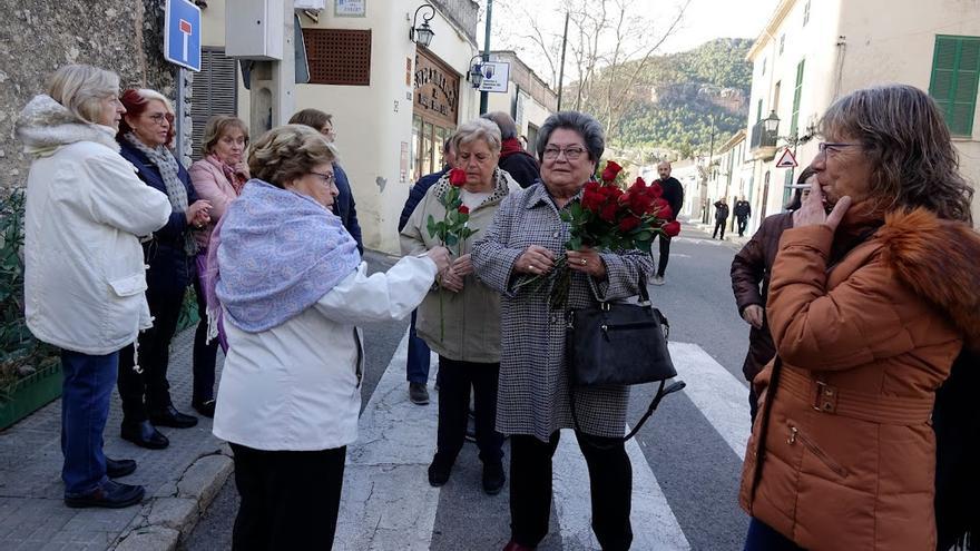 Los participantes reparten rosas antes de la procesión.