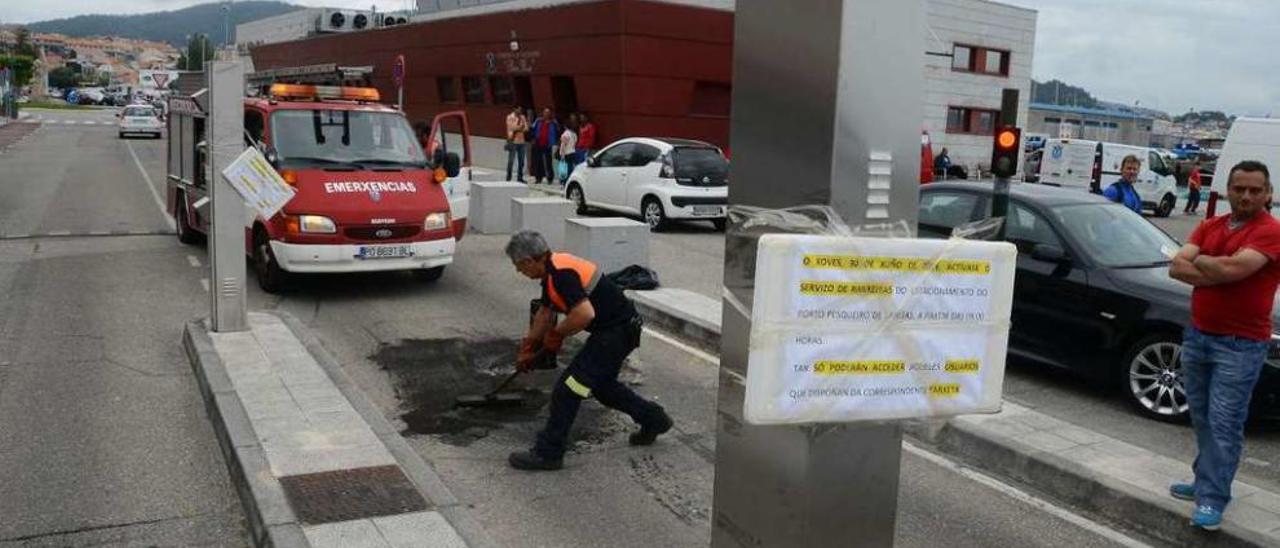 Protección Civil, ayer, limpiando la zona de acceso al puerto tras un incidente con la pilona. // G.Núñez