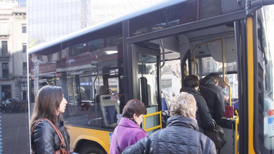 Passatgers agafant un autobús a Girona.