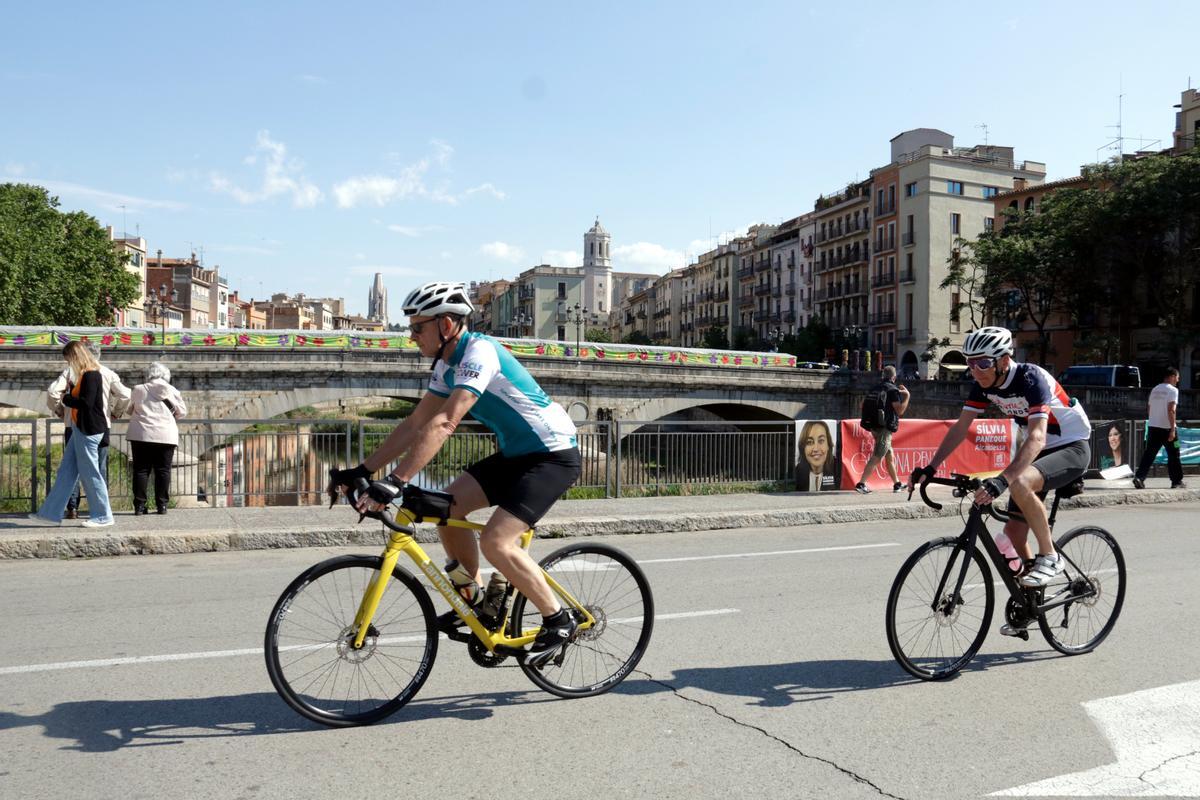 Uns ciclistes passant per la plaça Catalunya de Girona