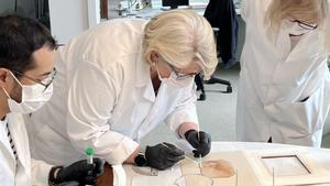 La bióloga forense Rhonda Roby (centro) toma muestras de un boceto en tiza roja del siglo XVI, quizás creado por Leonardo da Vinci, para un análisis de ADN en abril de 2024.