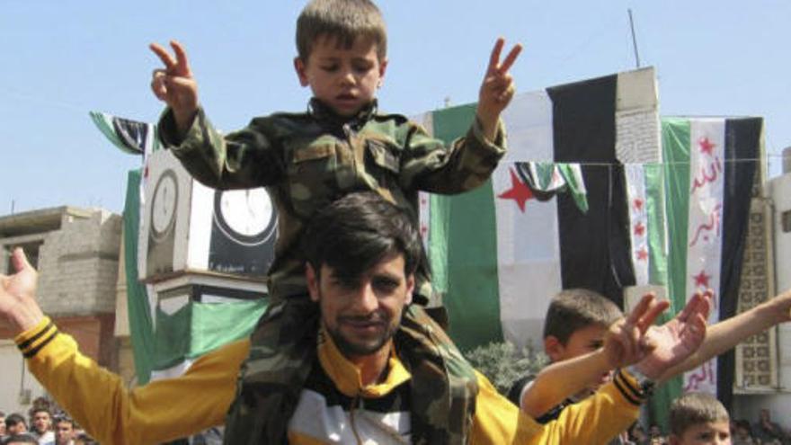 Un niño y un adulto, durante una manifestación opositora en Idlib.