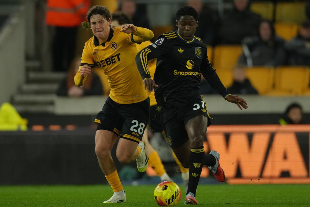 Wolverhampton Wanderers' Fer Lopez, left, and Manchester United's Kobbie Mainoo fight for the ball during the Premier League soccer match between Wolverhampton Wandere and Manchester United in Wolverhampton, England Monday, Dec. 8, 2025. (AP Photo/Dave Shopland)