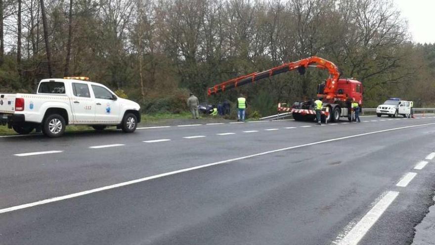 Una grúa procede a retirar el vehículo volcado en el margen de la carretera en Moimenta. // Emerxencias