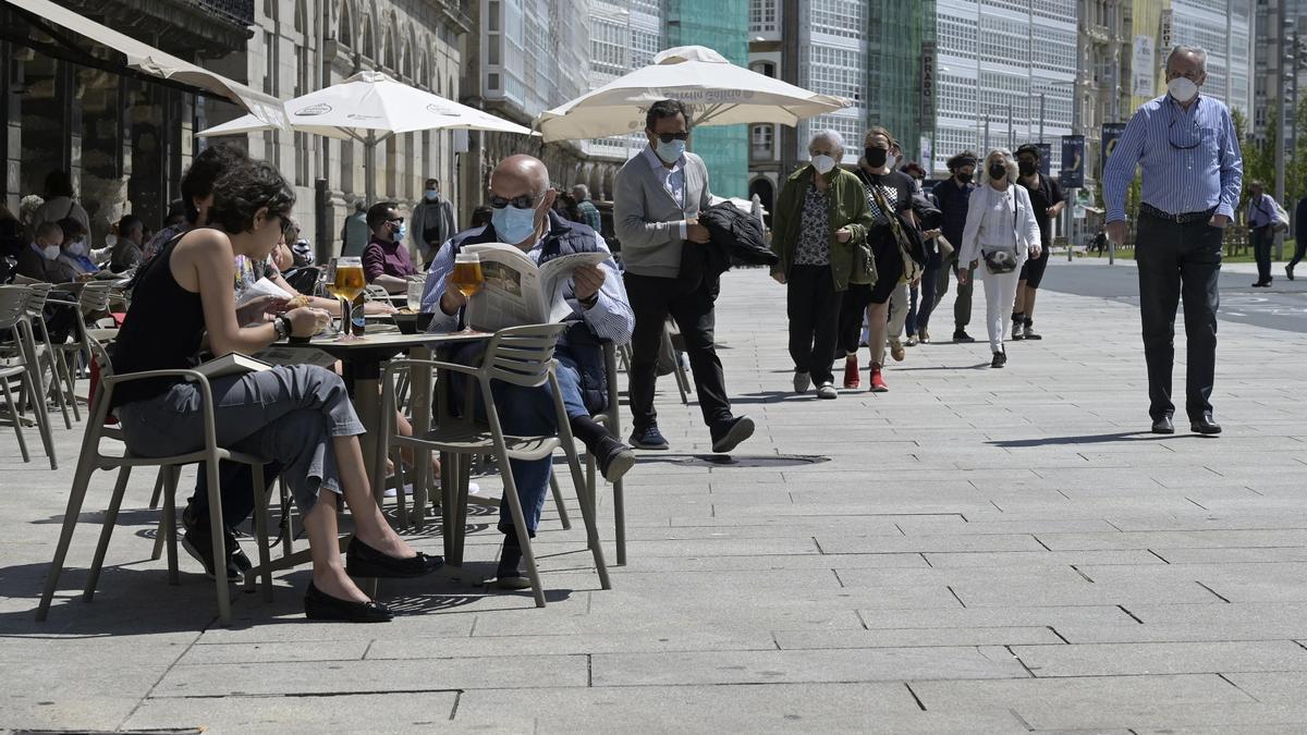 Personas tomando algo en la terraza de una bar.