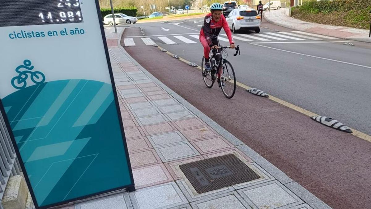 Un ciclista pasa por delante del contador de bicicletas de Pola de Siero.