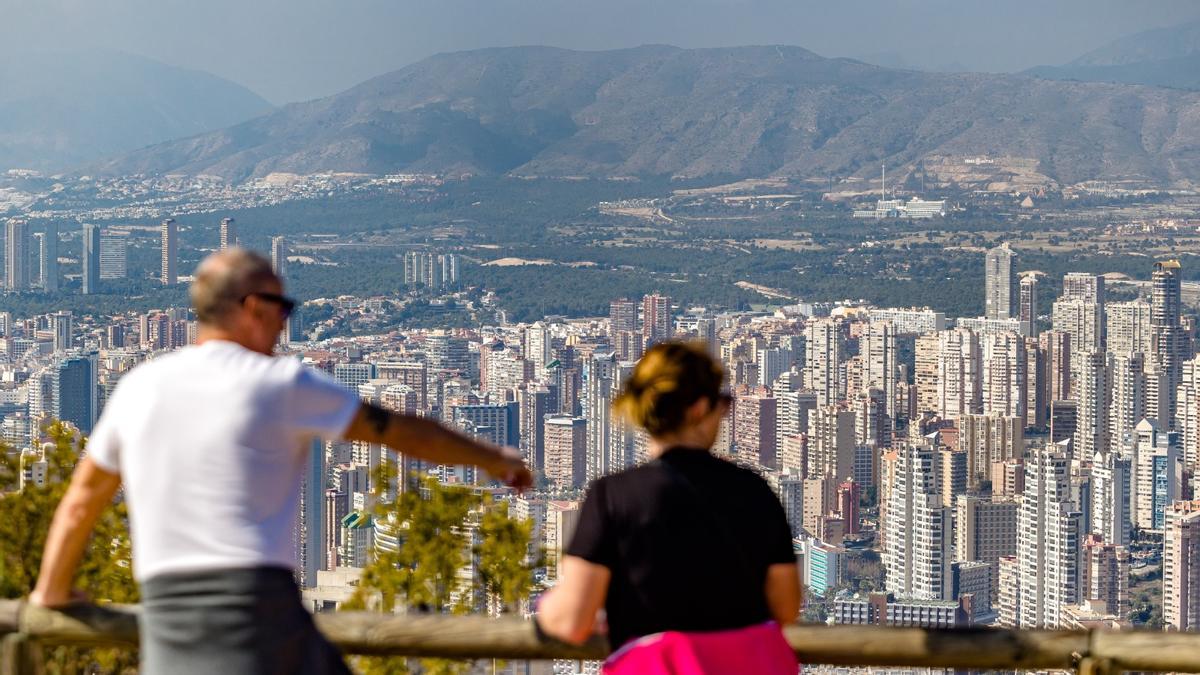 Una pareja de turistas observa Benidorm desde un mirador de Sierra Helada