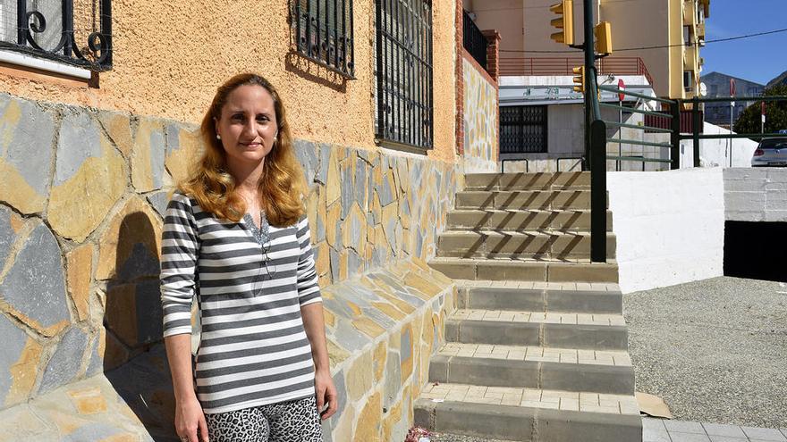 Cristina Expósito, junto a la obra municipal que facilita que niños y jóvenes suban a las ventanas de su casa. Detrás, la escalera con el último tramo sin barandilla.