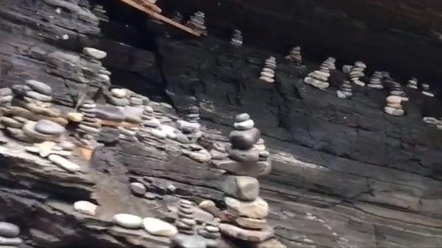 Los montones de piedras apilados en los pliegues de uno de los acantilados de la playa de As Catedrais