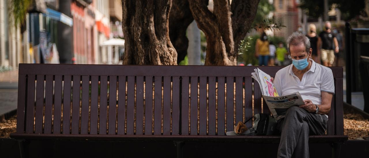 Un hombre lee una edición del periódico EL DÍA en un banco de Santa Cruz.