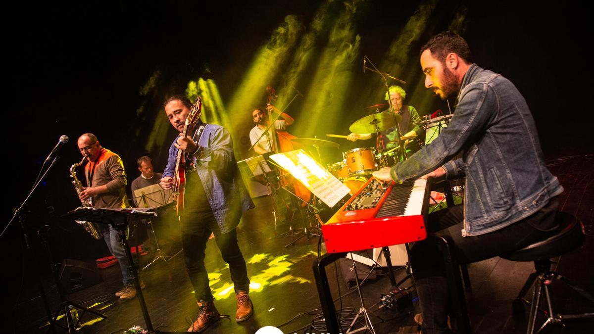 Javier Alcántara, en el centro con la guitarra, con su grupo en un concierto.