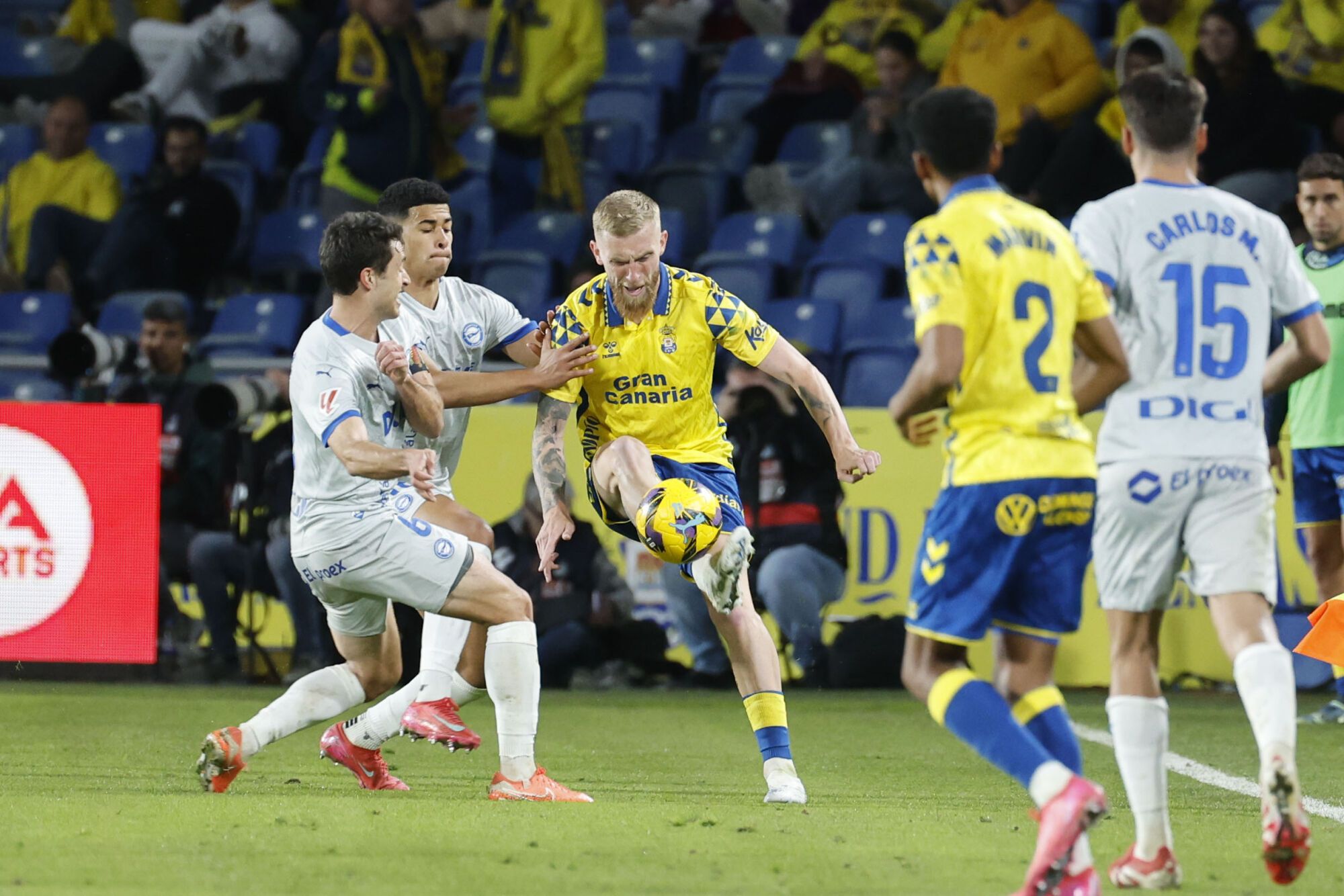 GRAFCAN5486. LAS PALMAS DE GRAN CANARIA, 14/03/2025.- El jugador de la UD Las Palmas McKenna (c) y el jugador del Deportivo Alavés Guevara (i) durante el partido correspondiente a la jornada 28 de LaLiga EA Sports disputado este viernes en el estadio de Gran Canaria, en Las Palmas de Gran Canaria. EFE/ Elvira Urquijo A.