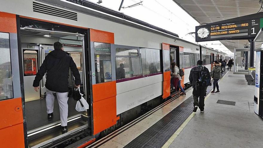 Passatgers pujant a un comboi aturat a l&#039;estació de Girona