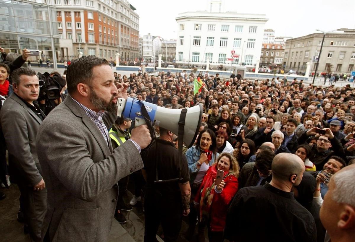 El candidato de Vox habla con un megáfono al publico que no pudo entrar al recinto en el que se celebraba un mitin en A Coruña.
