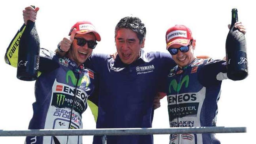 Unos sonrientes Lorenzo (1º) y Rossi (2º) celebran con Tsuji Kouichi, director de la sección deportiva de Yamaha, el podio de ambos en el GP de Le Mans en mayo de 2015.