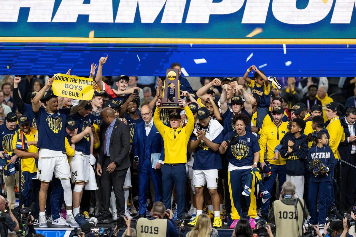 Dusty May, entrenador de Michigan, levanta el título nacional.