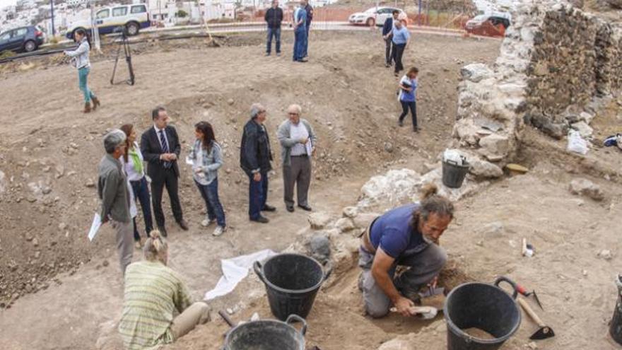 Arqueólogos trabajando en el yacimiento, mientras las autoridades observan el terreno. | josé carlos guerra