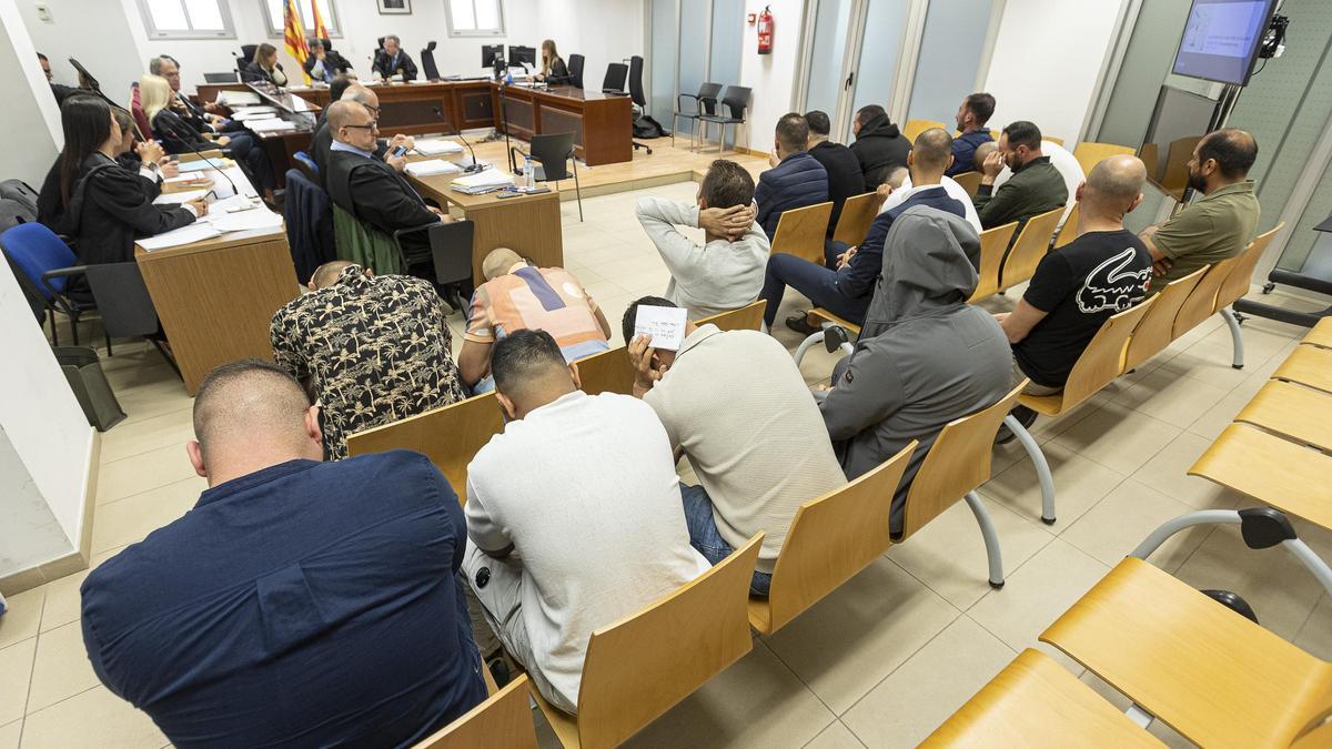 Los acusados sentados de espaldas en el banquillo al inicio de la vista oral en la Audiencia de Alicante.