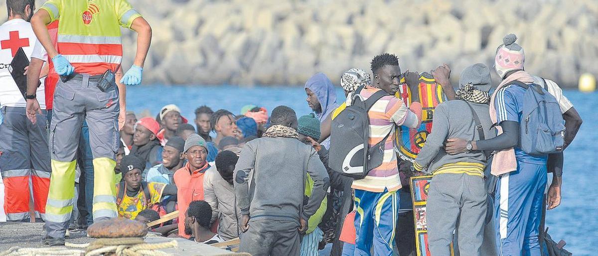 Migrantes esperan para desembarcar del cayuco en el puerto herreño de La Restinga.