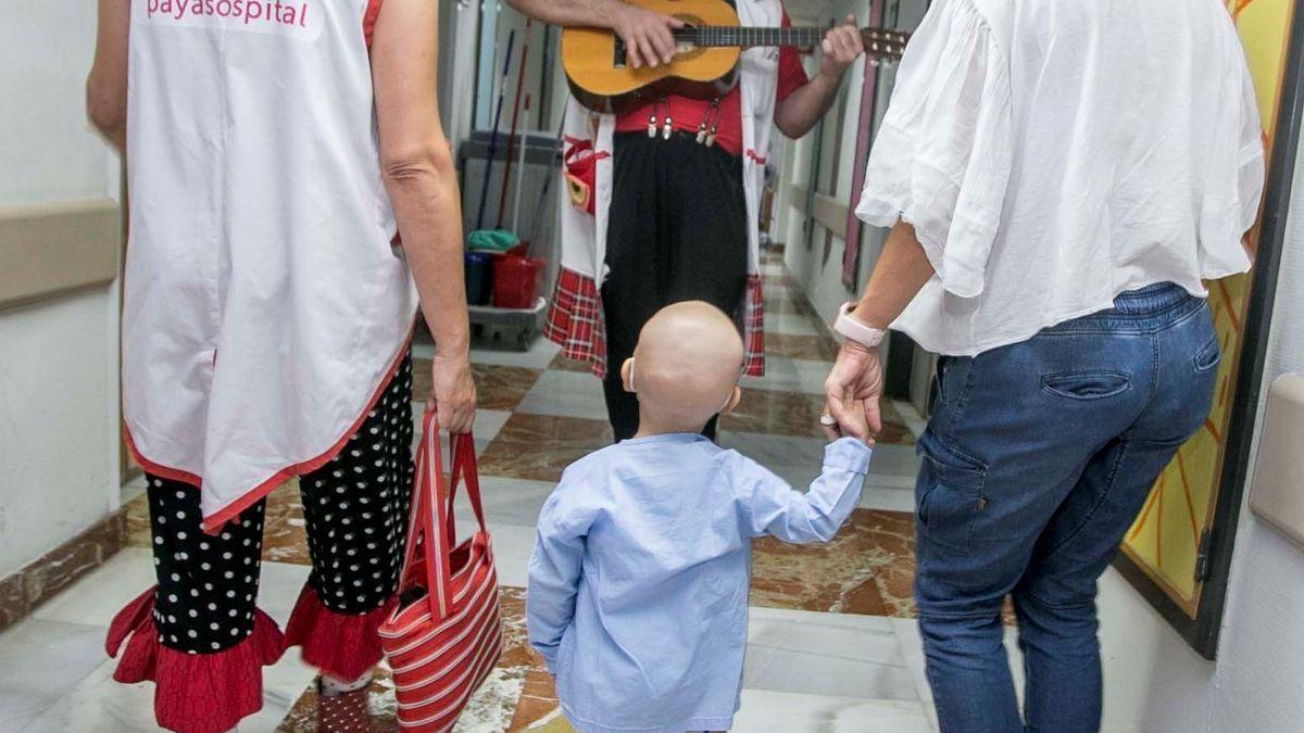 Un niño escucha a un músico en el Hospital Doctor Balmis de Alicante.