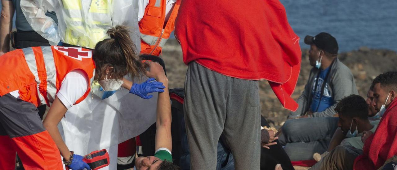 Miembros de la Cruz Roja y de la Guardia Civil atienden a los 30 inmigrantes llegados a los Ancones, Lanzarote.  | | EFE/ ADRIEL PERDOMO