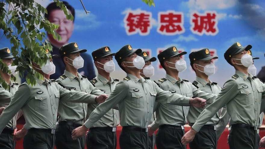 Soldados chinos desfilan, ayer en Pekín, ante un retrato del presidente Xi Jinping. // Andy Wong