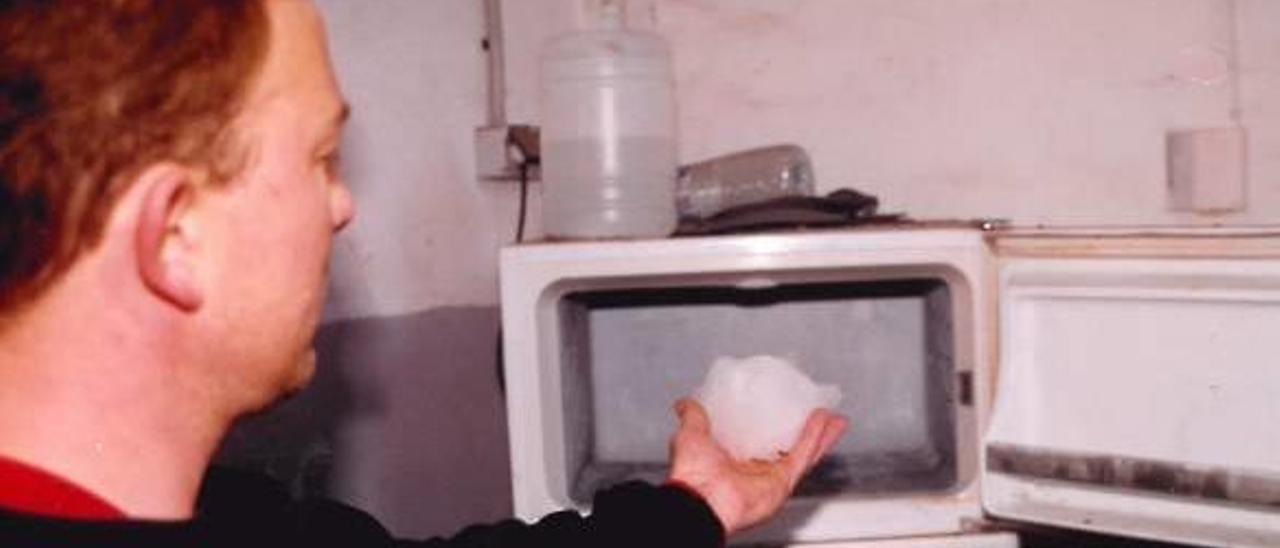 Un trabajador de la empresa de l&#039;Alcúdia muestra uno de los trozos de hielo caídos del cielo.