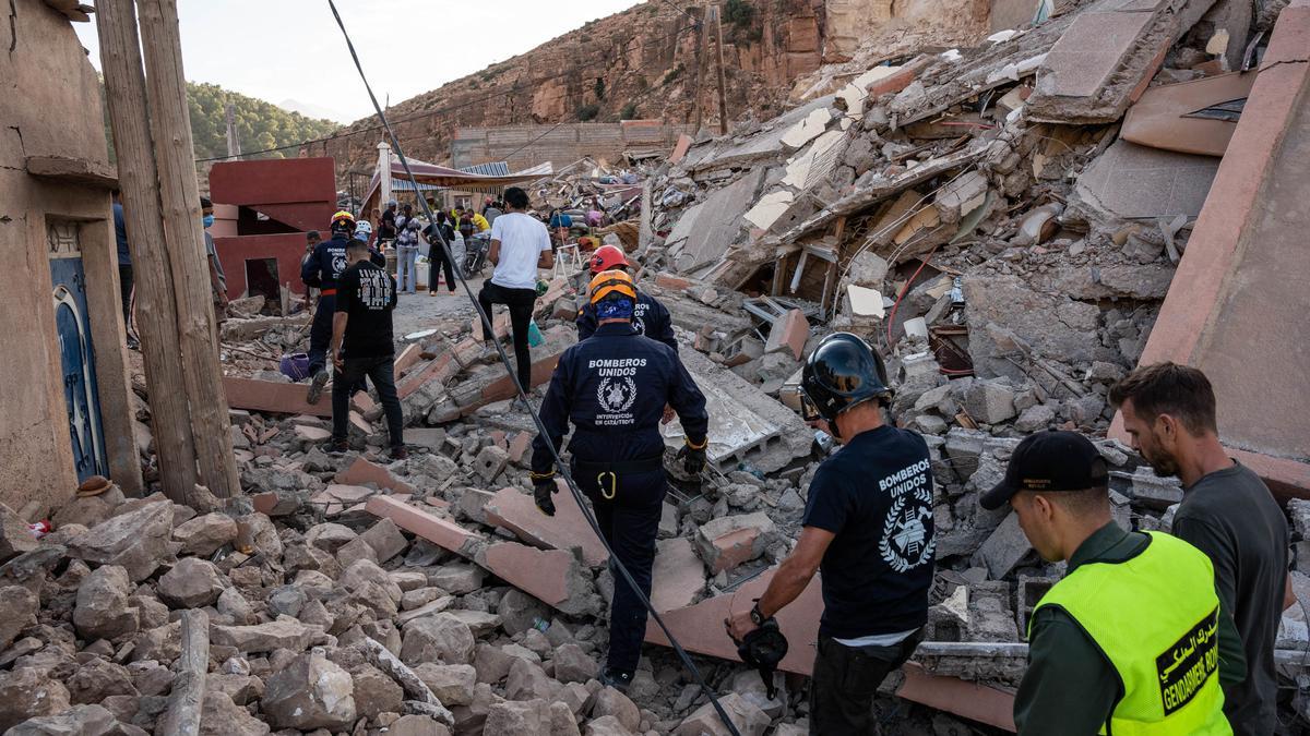 Varios bomberos de la ONG BUSF caminan por una zona destruida por el terremoto, a 12 de septiembre de 2023, en Imi N’Tala (Marruecos). (Foto de archivo).