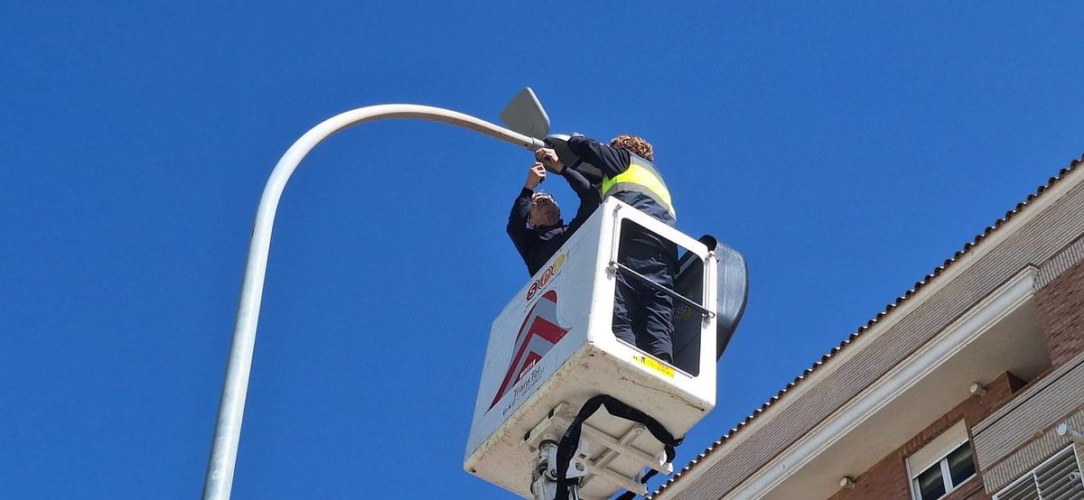Imagen de detalle de los empleados de Servicios Públicos cambiando una de las lámparas de la avenida Mediterrani.