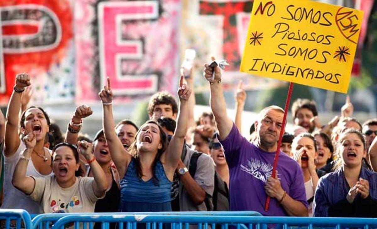 Els manifestants aixequen els braços com a protesta per la gestió de la crisi econòmica, a prop del Congrés, a Madrid.