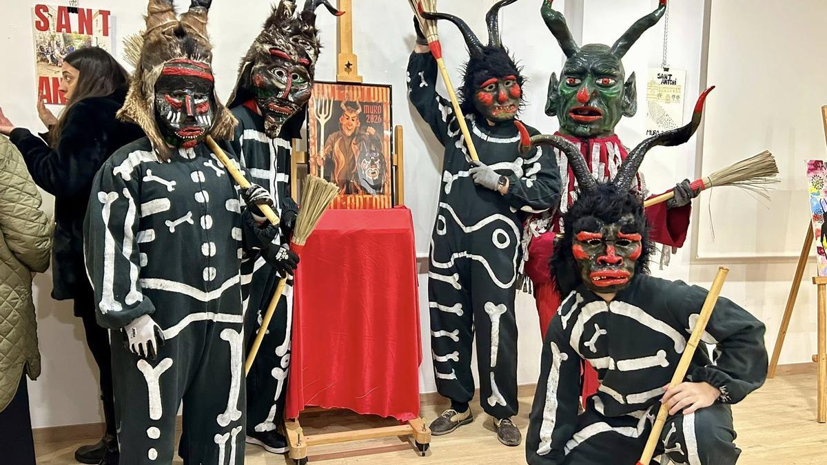 'Dimonis' de Muro posan con el polémico cartel.