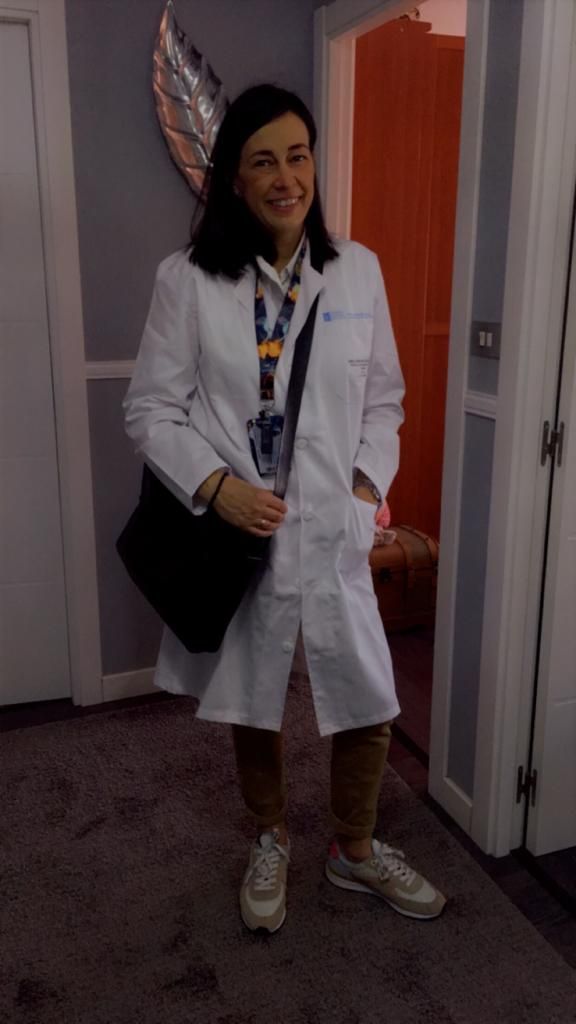 Eva, con su bata de médico saliendo de su casa