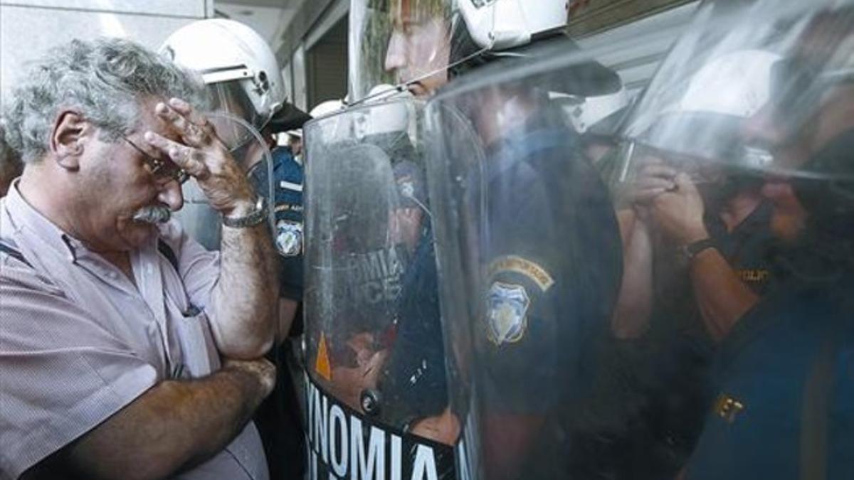 Un profesor topa con un escudo policial durante una reciente protesta de maestros contra los recortes, en Atenas.