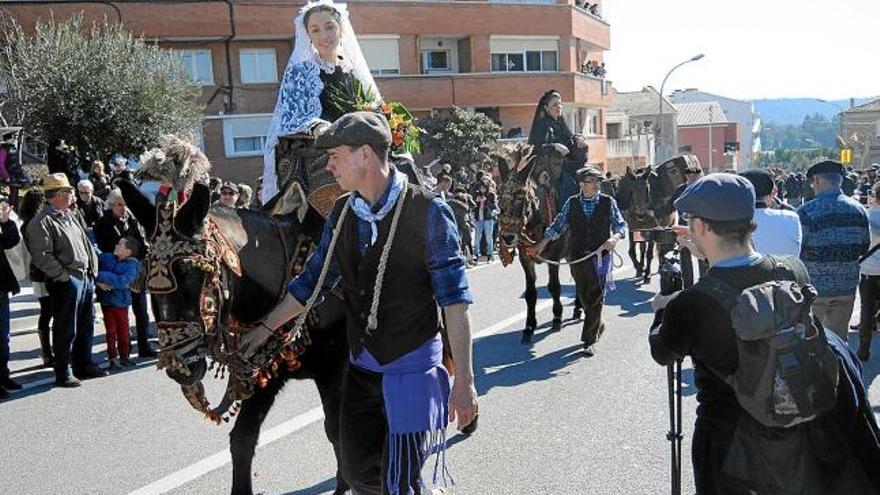 La núvia, sobre un dels animals carregat de guarniments, i al darrere la mare de la núvia durant la desfilada