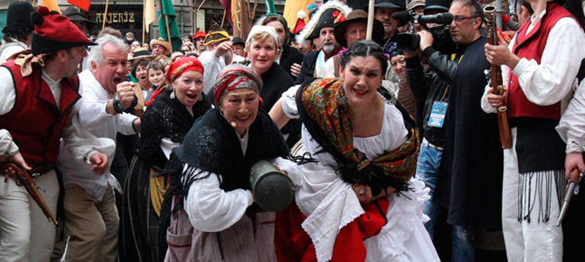 Mujeres con un ariete para tirar la Porta de Gamboa. / R.G.