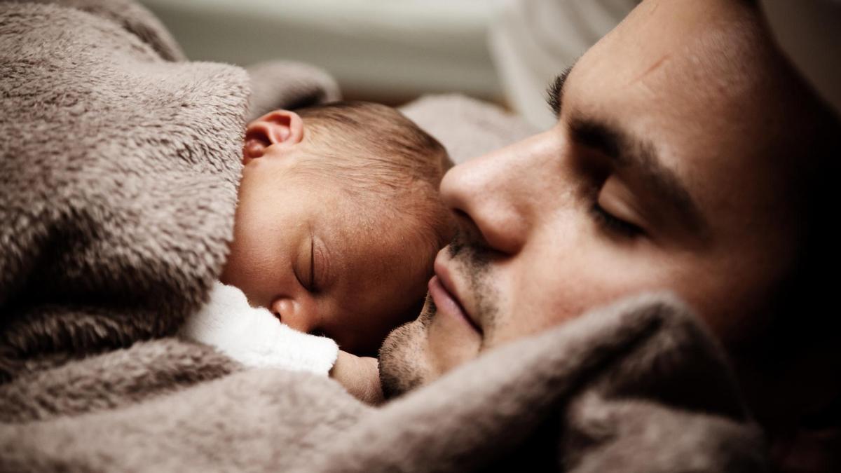 Un bebé durmiendo con su padre.