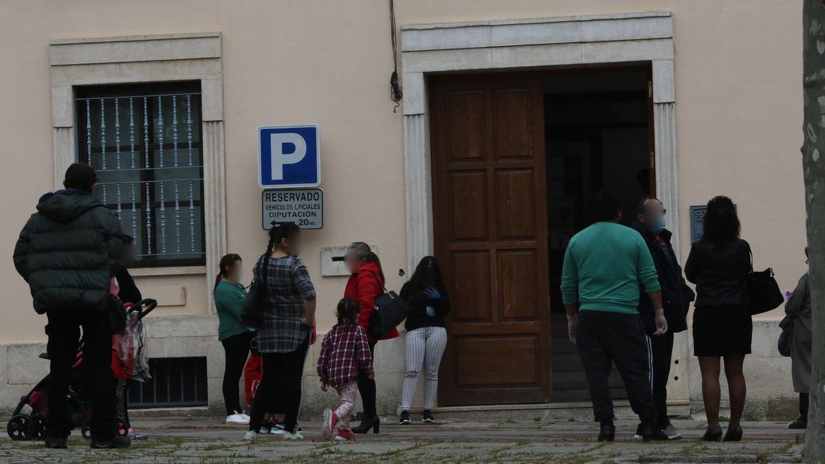 Varias personas esperan a ser atendidas en la sede de Cáritas, durante el confinamiento primaveral.