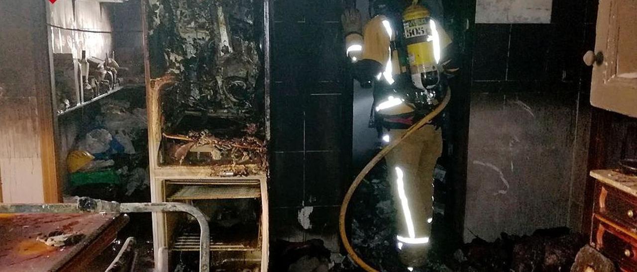 Bomberos interviniendo en el incendio de un piso de Elche