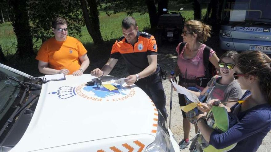 Voluntarios de Protección Civil de Valga sellan las credenciales de un grupo de peregrinas, ayer.  // Noé Parga