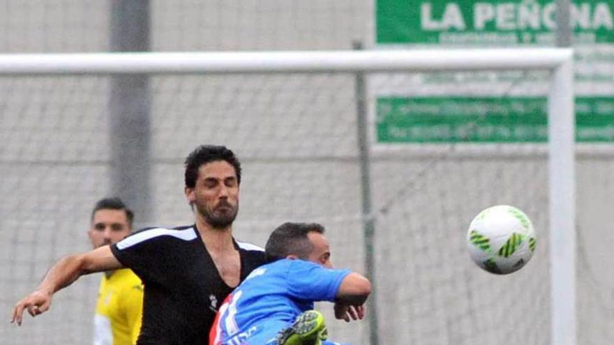 Nacho Fernández pelea un balón con Omar Sampedro (Langreo).