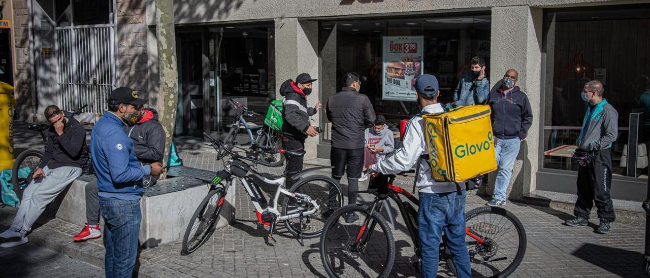 Repartidores de distintas ’apps’ de comida a domicilio esperando a la puerta de un restaurante.