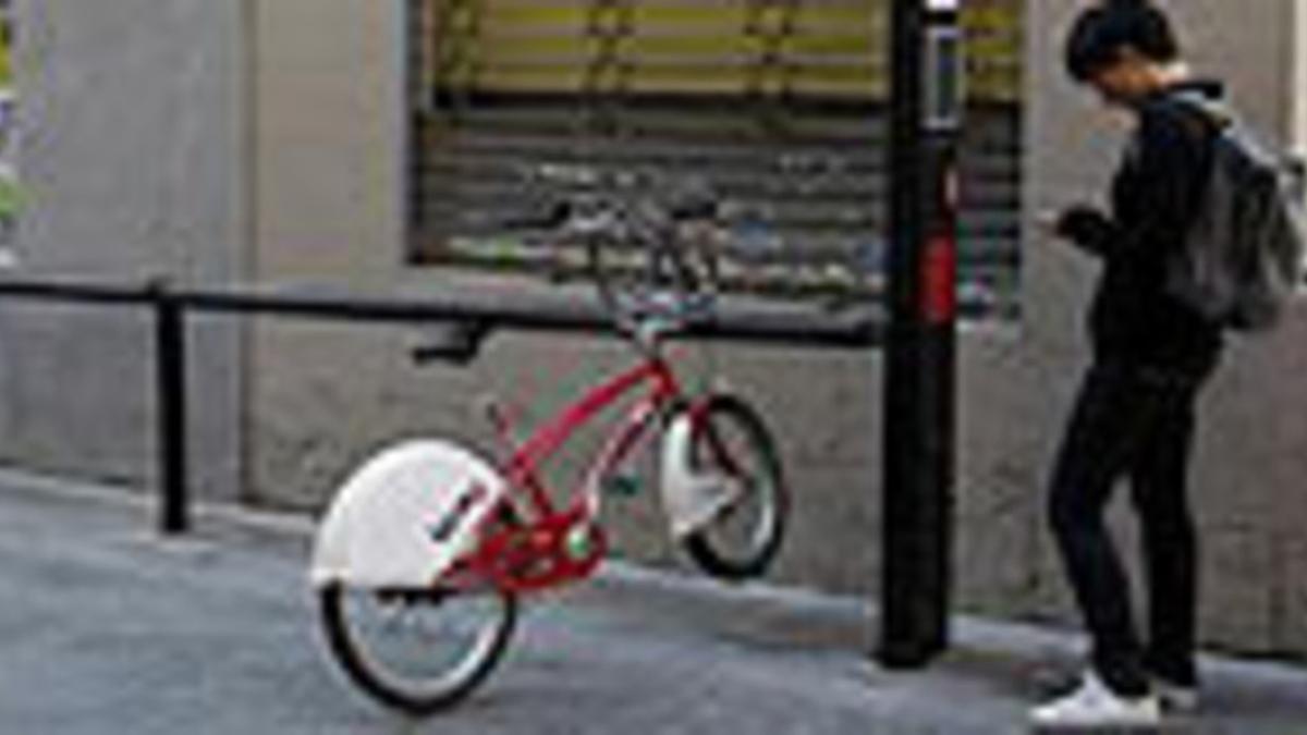 Una usuaria, junto a una única bicicleta, inservible, en la calle de Cano, en Gràcia.